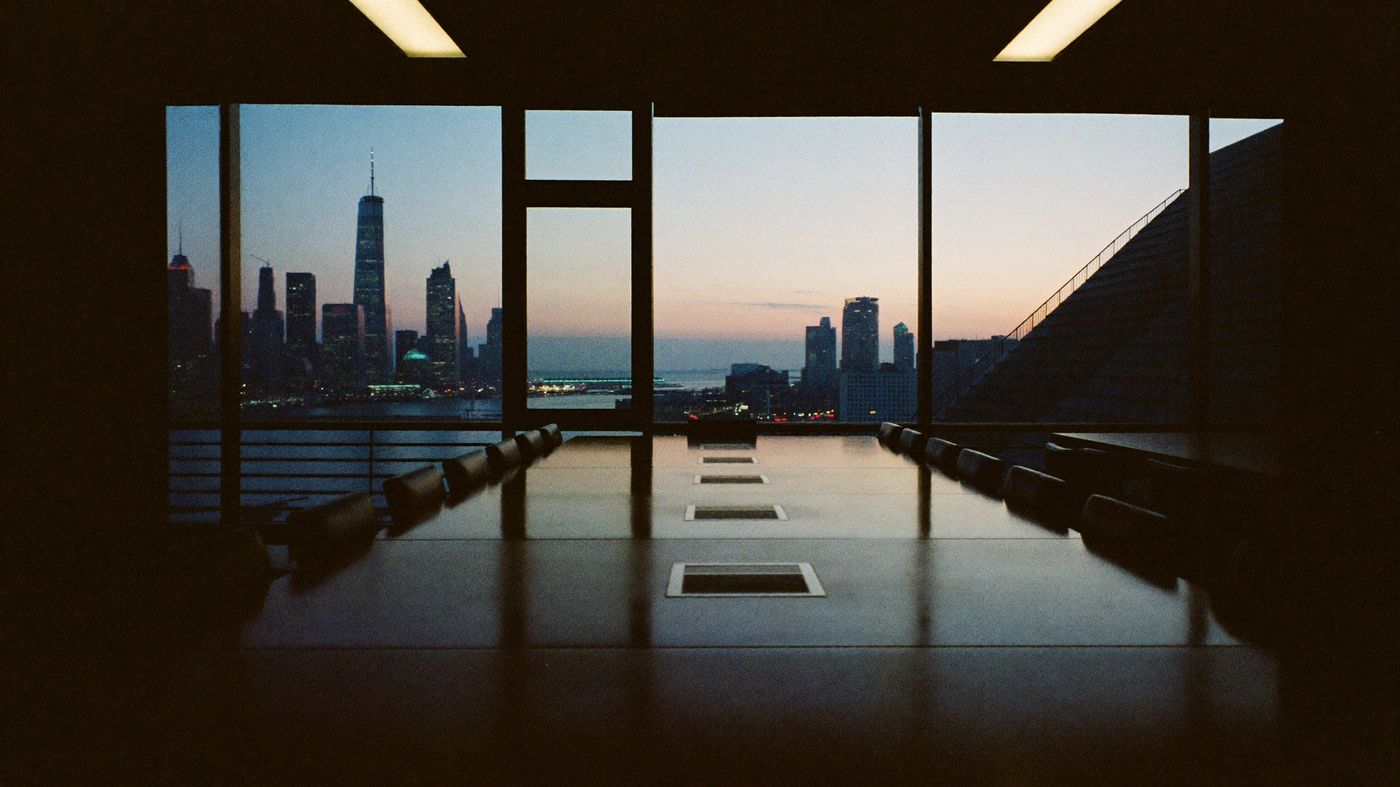 Modern boardroom at dusk overlooking a city skyline