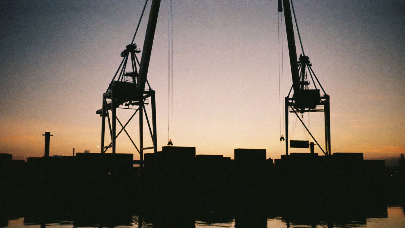 Container port cranes silhouetted at dawn